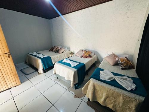 a room with three beds in a room at Pousada Pesque Pague Jango in Cuiabá