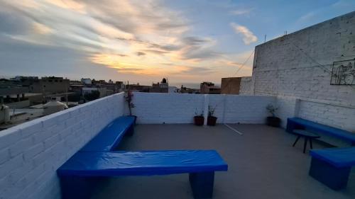 a rooftop with two blue benches on a building at Dpto Cerca a la playa caminando A in Pacasmayo