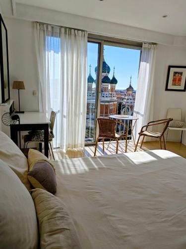 - une chambre avec un lit et une vue sur la ville dans l'établissement 3P 72m2 Climatisé Vue exceptionnelle Cathédrale St Nicolas et Mer, à Nice