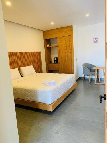 a bedroom with a bed and a desk and a chair at Casa Begonias Hotel mas Villas in Jiutepec