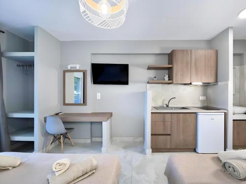 a kitchen with a sink and a desk in a room at Marias Apartments in Sarti