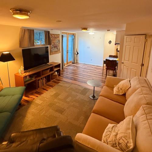 a living room with a couch and a flat screen tv at Southeast Portland Parkside Gem on Mount Tabor in Portland