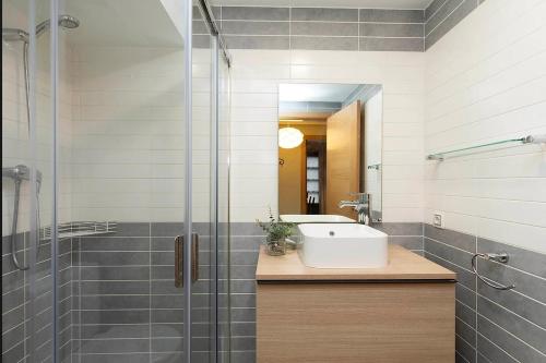a bathroom with a sink and a glass shower at El Bosque del Sapo in El Pueyo de Jaca