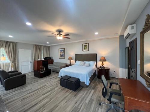 a bedroom with a bed and a desk and a couch at Las Lomas Apart Hotel in Tela