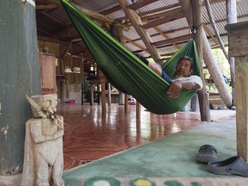 a man sleeping in a hammock in a building at Rincon Ecologico Cultural Terraba in Buenos Aires