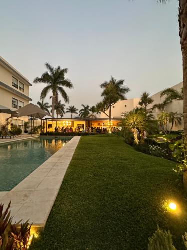 a resort with a swimming pool and palm trees at Casa Begonias Hotel mas Villas in Jiutepec
