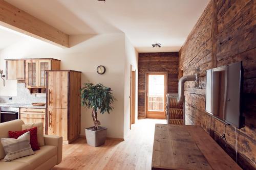 ein Wohnzimmer mit einem Sofa und einer Holzwand in der Unterkunft Sandrisser-Hütte in Innerkrems