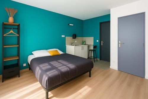 une chambre avec un lit et un mur bleu dans l'établissement Appartement Cerf3-Centre ville Meaux-Gare-Disney, à Meaux