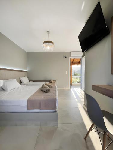 a bedroom with a bed and a flat screen tv at Marias Apartments in Sarti