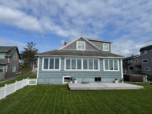 a blue house with a white fence and a yard at Seaside Beach Front House on the Promenade in Seaside