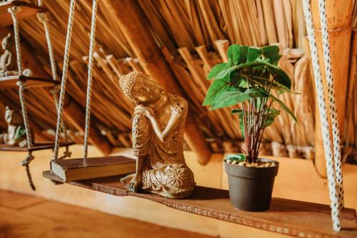 a statue of a woman sitting on a shelf next to a plant at Kasakolà in Palomino