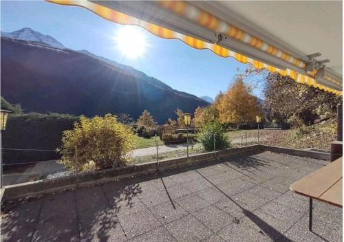 a patio with a fence and mountains in the background at Grosszügige, charmante Wohnung in den Bergen in Breiten