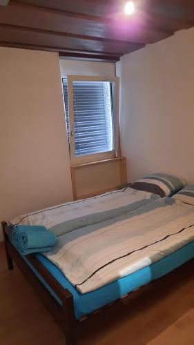 a large bed in a room with a window at Grosszügige, charmante Wohnung in den Bergen in Breiten