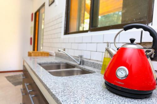 a red tea kettle sitting on a kitchen counter at Casa Quinta Los Molinos 1912 in Estación Las Flores