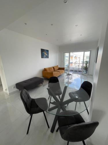 un salon avec une table en verre et des chaises dans l'établissement Sea view apartment, à Cagnes-sur-Mer