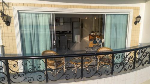 a balcony with chairs and a view of a kitchen at Apartamento Frente Mar in Arraial do Cabo