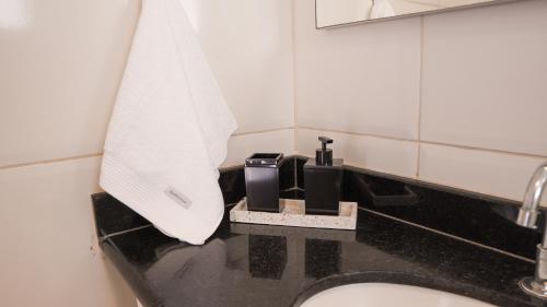 a bathroom with a sink and a white towel at Apartamento Frente Mar in Arraial do Cabo