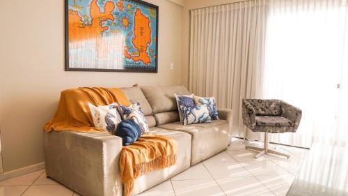 a living room with a couch and a chair at Apartamento Frente Mar in Arraial do Cabo