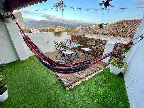 a hammock on a patio with a table and chairs at Ignis Rural Apartment - Casillas Valle de Ayora in Jalance