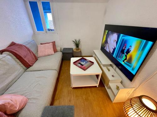 a living room with a couch and a flat screen tv at Ignis Rural Apartment - Casillas Valle de Ayora in Jalance