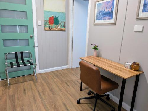 an office with a desk and a chair and a door at Cute Cottage - 2 Bedrooms - City & Strand Beach Location in Townsville