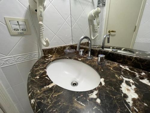 a white sink in a bathroom with a phone at Flat 4 Estrelas Pinheiros in Sao Paulo