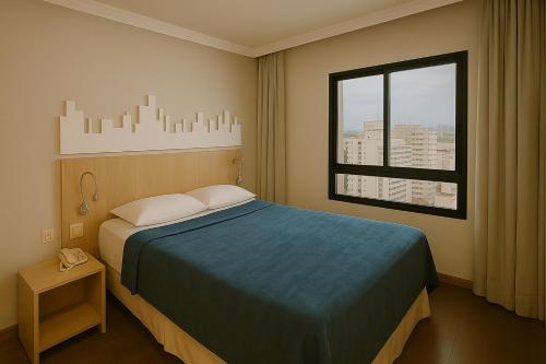 a hotel room with a bed and a window at Flat 4 Estrelas Pinheiros in Sao Paulo
