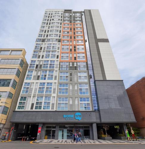 a tall building with people standing in front of it at Someone Hotel in Yeosu