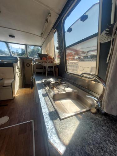 a kitchen in an rv with a sink in it at Douro Houseboats in Marco de Canavezes