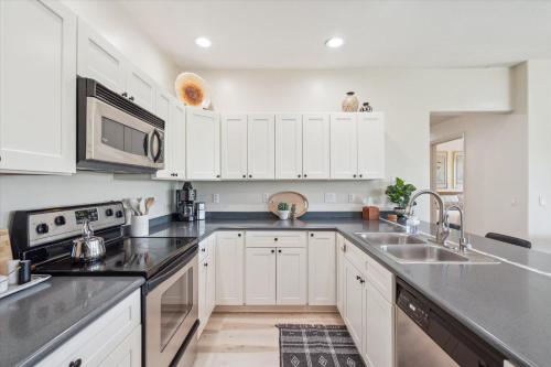 a kitchen with white cabinets and stainless steel appliances at Panorama View - Mountain Views - Community Pool in Fountain Hills