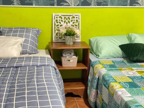 a bedroom with two beds and a table with a plant on it at Tunco Bambú Room 1 in Tamanique