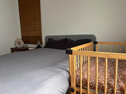 a bed with a wooden crib in a bedroom at A cozy home between Osaka and Kyoto -UNiCO- in Takatuki