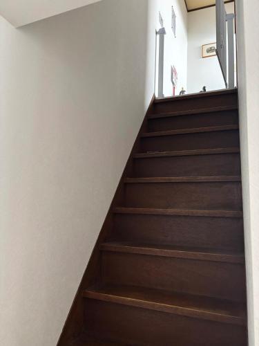 a staircase in a house with wooden stairs at A cozy home between Osaka and Kyoto -UNiCO- in Takatuki