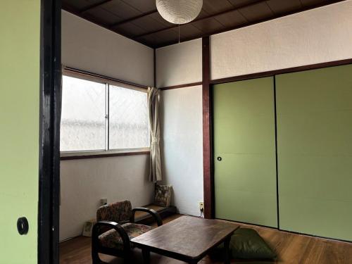 a room with a table and chairs and a window at A cozy home between Osaka and Kyoto -UNiCO- in Takatuki