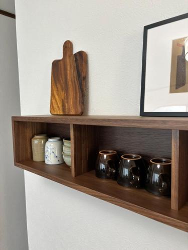 a wooden shelf with pots and jars on it at A cozy home between Osaka and Kyoto -UNiCO- in Takatuki