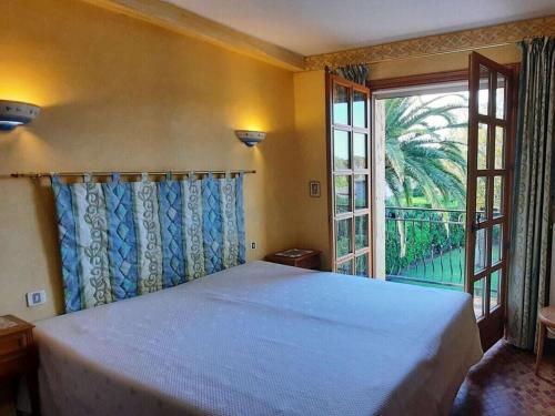 une chambre avec un grand lit et une grande fenêtre dans l'établissement Villa in La Croix Valmer with Wifi, à La Croix-Valmer