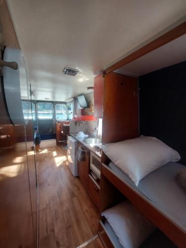 a small room with a bunk bed and a kitchen at Douro Houseboats in Marco de Canavezes