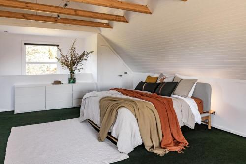 a white bedroom with a bed and a window at Navigators Rest in Gordon