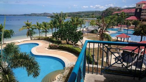 une vue sur la piscine d'un complexe hôtelier dans l'établissement Nasugbu Resort, Beachfront Condo in Canyon Cove A1-301, à Nasugbu