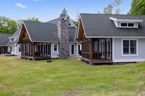 a house with a stone chimney on top of a yard at Port Cunnington Lodge in Dwight