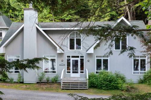 a white house with a porch and a porch swing at Port Cunnington Lodge in Dwight