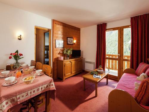 un salon avec une table et un canapé dans l'établissement Chalet in Savoie with Heated Pool & Mountain View, à Valfréjus