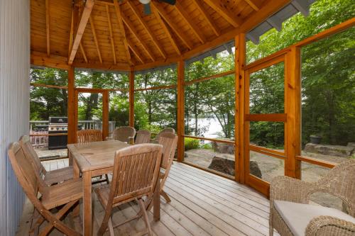 a dining room with a table and chairs on a deck at Port Cunnington Lodge in Dwight