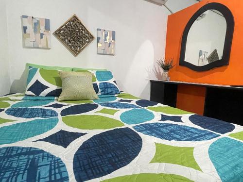 a bedroom with a bed with a colorful quilt at Tunco Sun Room 2 in Tamanique