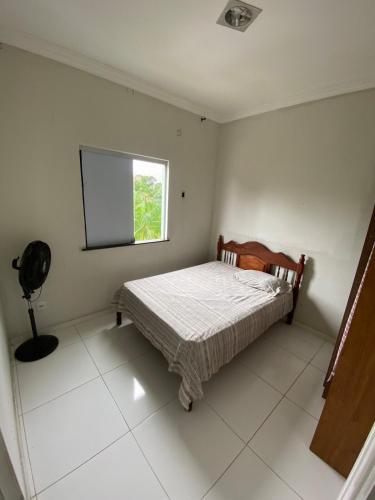 a small bedroom with a bed and a window at Alugo apartamento COP 30 in Ananindeua