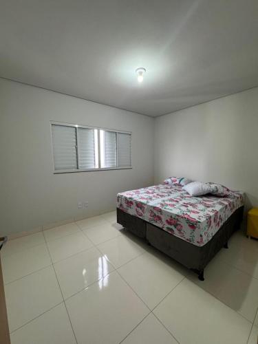 a bedroom with a bed and a window at Apartamento Oliveira in Sinop