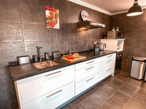 a kitchen with white cabinets and a sink at Bona Vista Villa Calpe in Calpe