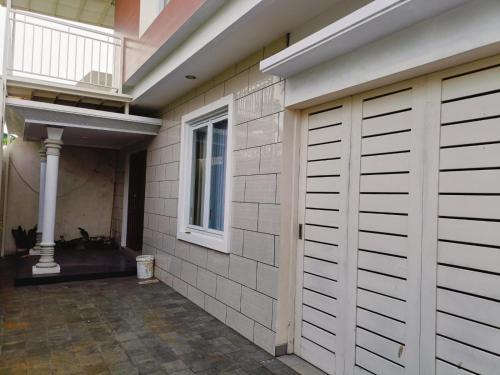 a house with a garage door and a porch at Lovena Luxury Homestay Solo in Grogol