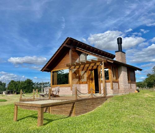 a log cabin with a bench in front of it at Cabanas Vale Verde in Praia Grande