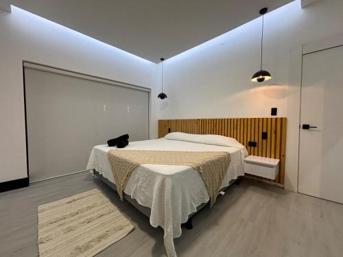 ein Schlafzimmer mit einem Bett, auf dem eine schwarze Katze sitzt in der Unterkunft Casa de lujo con piscina en Malacatos in Loja